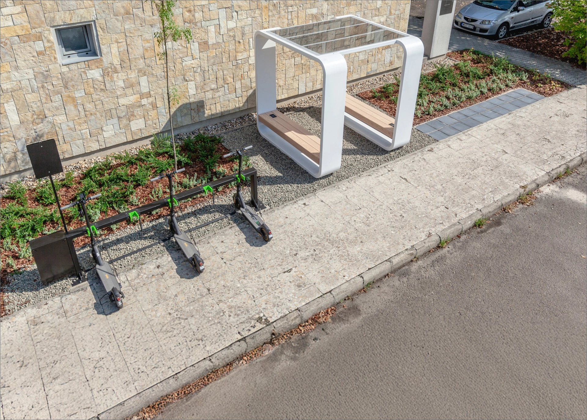 Kuube solar Smart Hub installed on a sidewalk with electric scooters parked nearby