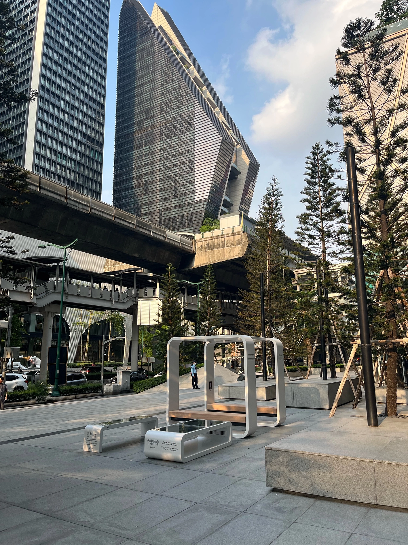 Kuube Smart Hub, Nano and Eco smart city stations installed in a modern plaza in Bangkok with high-rise buildings and urban greenery.